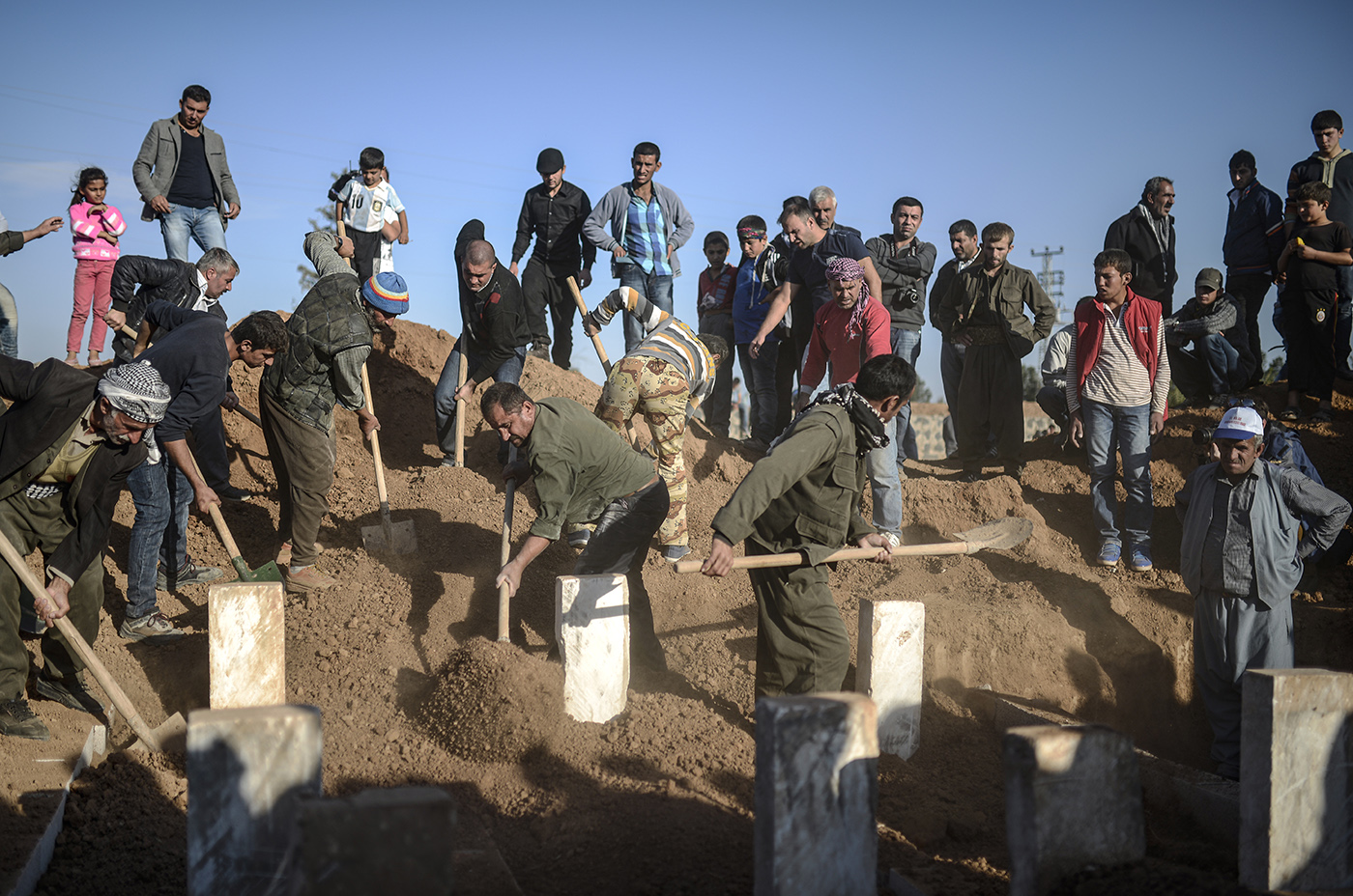 People dig for graves who were killed in Syria conflict in Sanliurfa, Turkey, 23 October 2014.