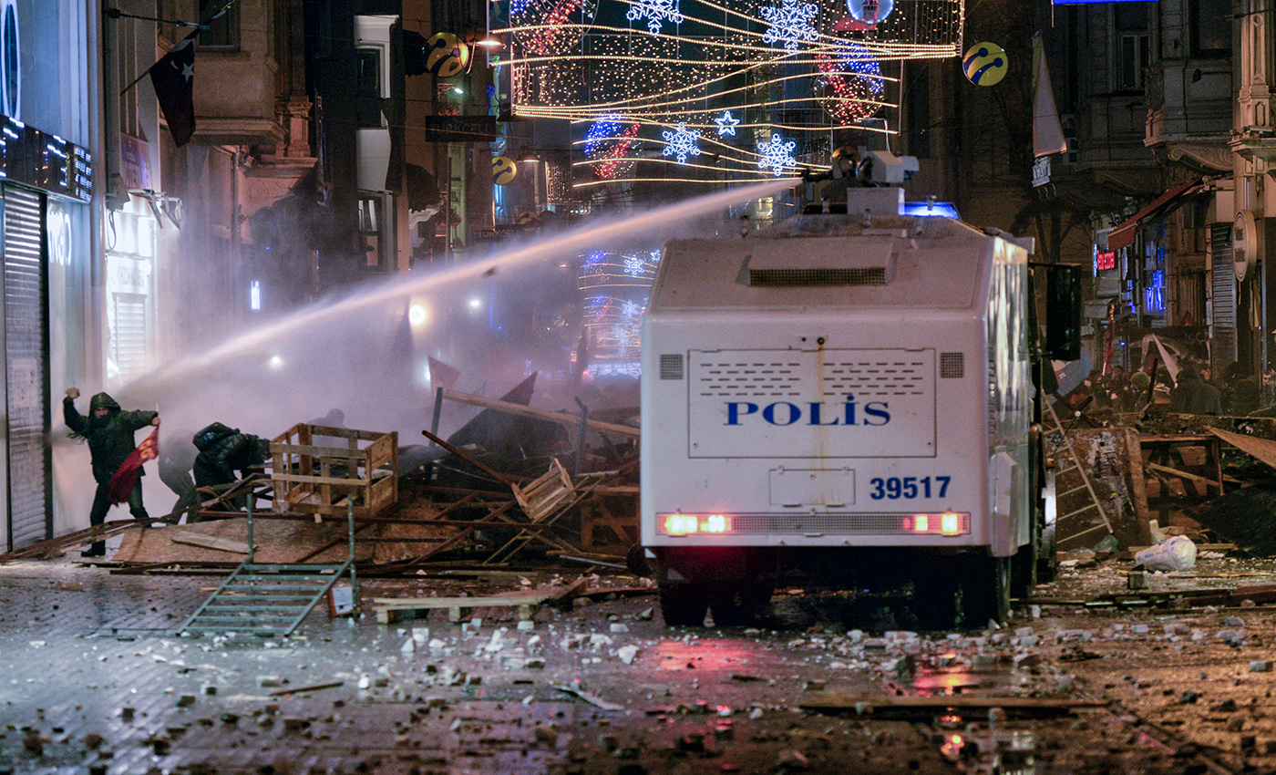 A Turkish police riot van uses a water cannon on a protestor during an anti-government protest in Istanbul, Turkey, 27 December 2013