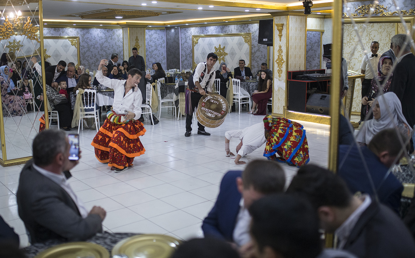 Osman Celik (R) take up money which is thrown by people while dance with his partner during a wedding in Istanbul, Turkey, 16 November 2019. 