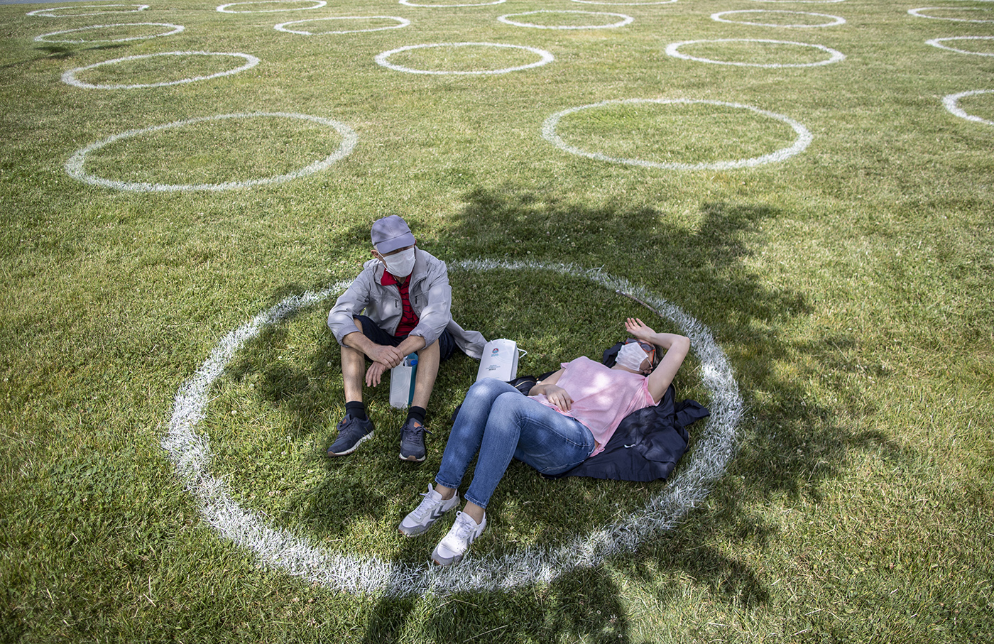 People wearing face masks sits in a circle marked by the municipality with social distance at the Maltepe Orhangazi city park in Istanbul, Turkey, 31 May 2020. The Turkish government allowed people aged 65 and above to go out for eight hours of a partial curfew imposed on senior citizens and those with chronic diseases, from going out in public and walking in open areas such as parks and gardens.