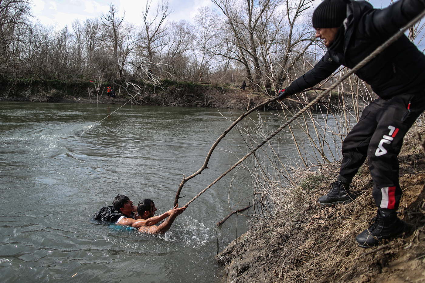 Refugees back to Turkish side with the help of a rope after they stuck for two days at a small island on the Meric (Evros) River to reach Greek territory as they try to reach to Europe, at the Turkish-Greek border, in Edirne, Turkey, 01 March 2020.