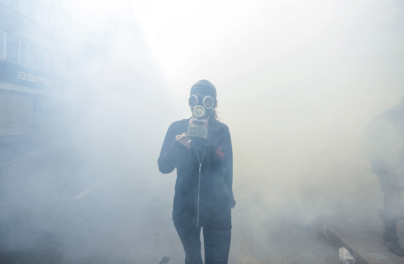 A protestor wearing gas mask walks in the smoke of gas thrown by the Turkish police during may day clashes in Istanbul, Turkey, 01 May 2014.