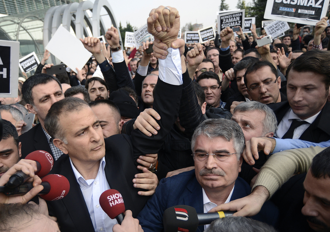 Turkish plain-clothed police officers detain Ekrem Dumanli (L) chief editor of Zaman newspapers, as supporters of Fethullah Gulen Movement surround of him as a part of a Turkish police operation targeting the media close to the Fethullah Gülen, in Istanbul, Turkey, 14 December 2014.