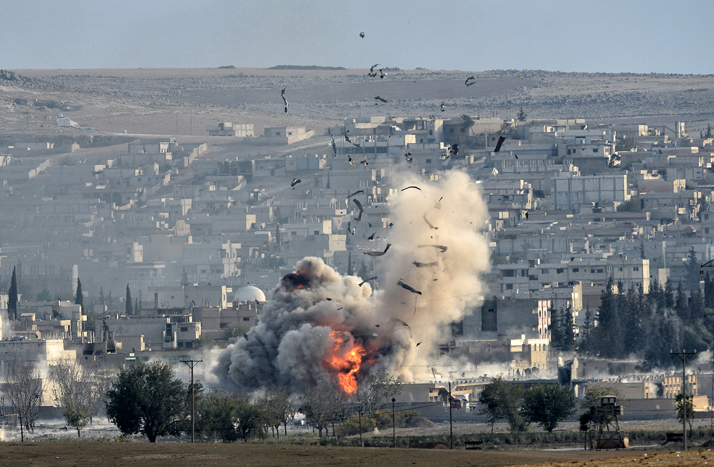 An explosion after an apparent US-led coalition airstrike on Kobane, Syria, as seen from the Turkish side of the border, near Suruc district, Sanliurfa, Turkey, 27 October 2014.