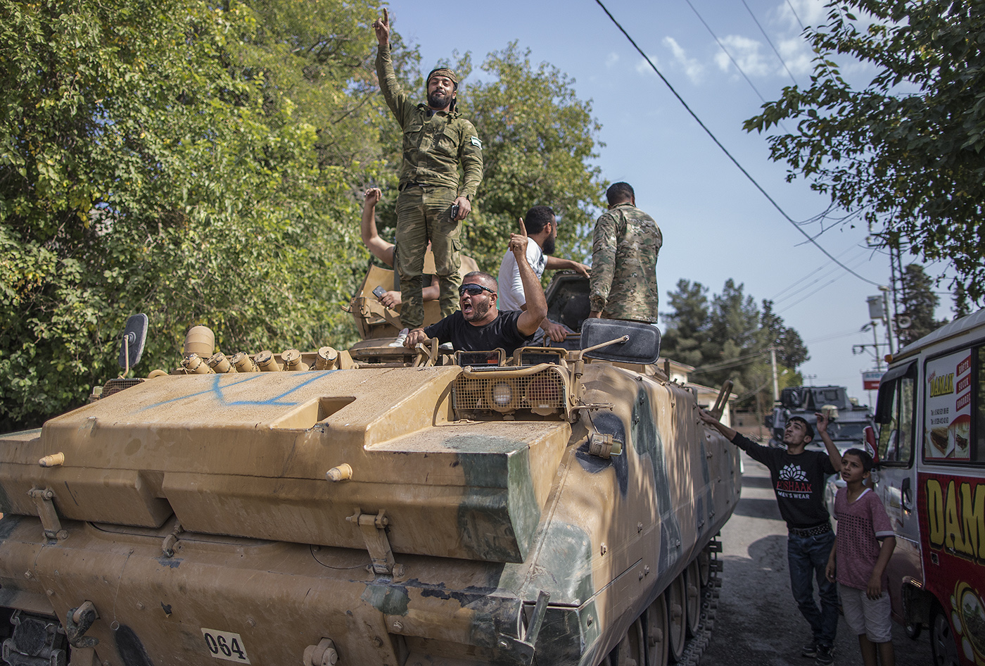 Turkish-backed Syrian fighters drive armored vehicles from Northern Syria for a military operation in Kurdish areas, near the Syrian border, in Akcakale district in Sanliurfa, Turkey, 18 October 2019. 