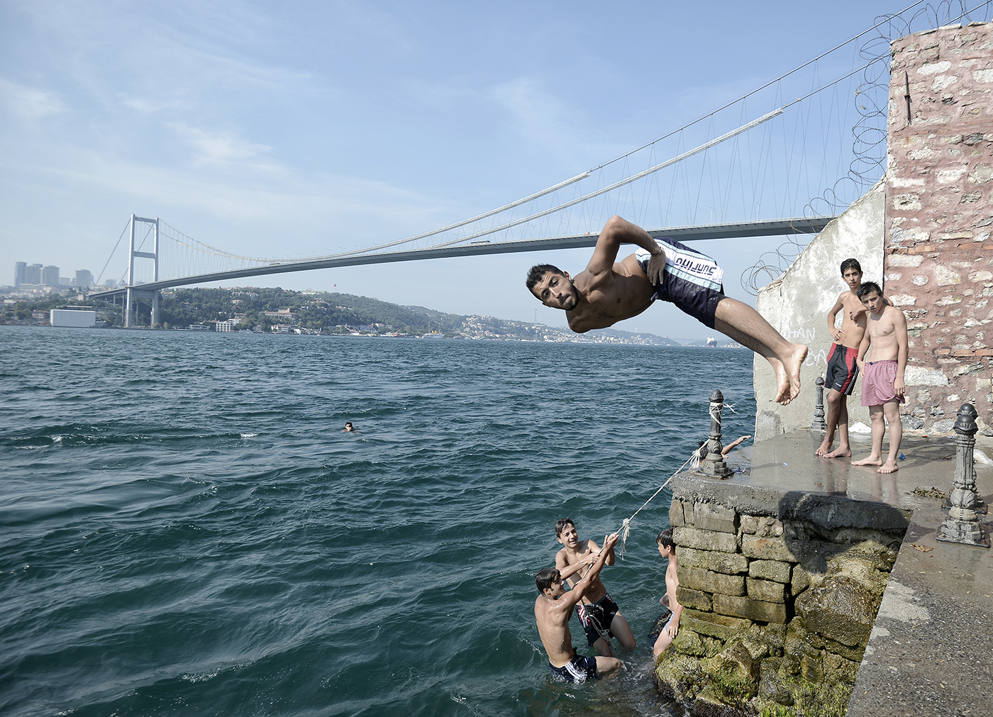 Turkish people enjoy a sunny day near by the Bosphorus Bridge in Istanbul, Turkey 22 August 2014.