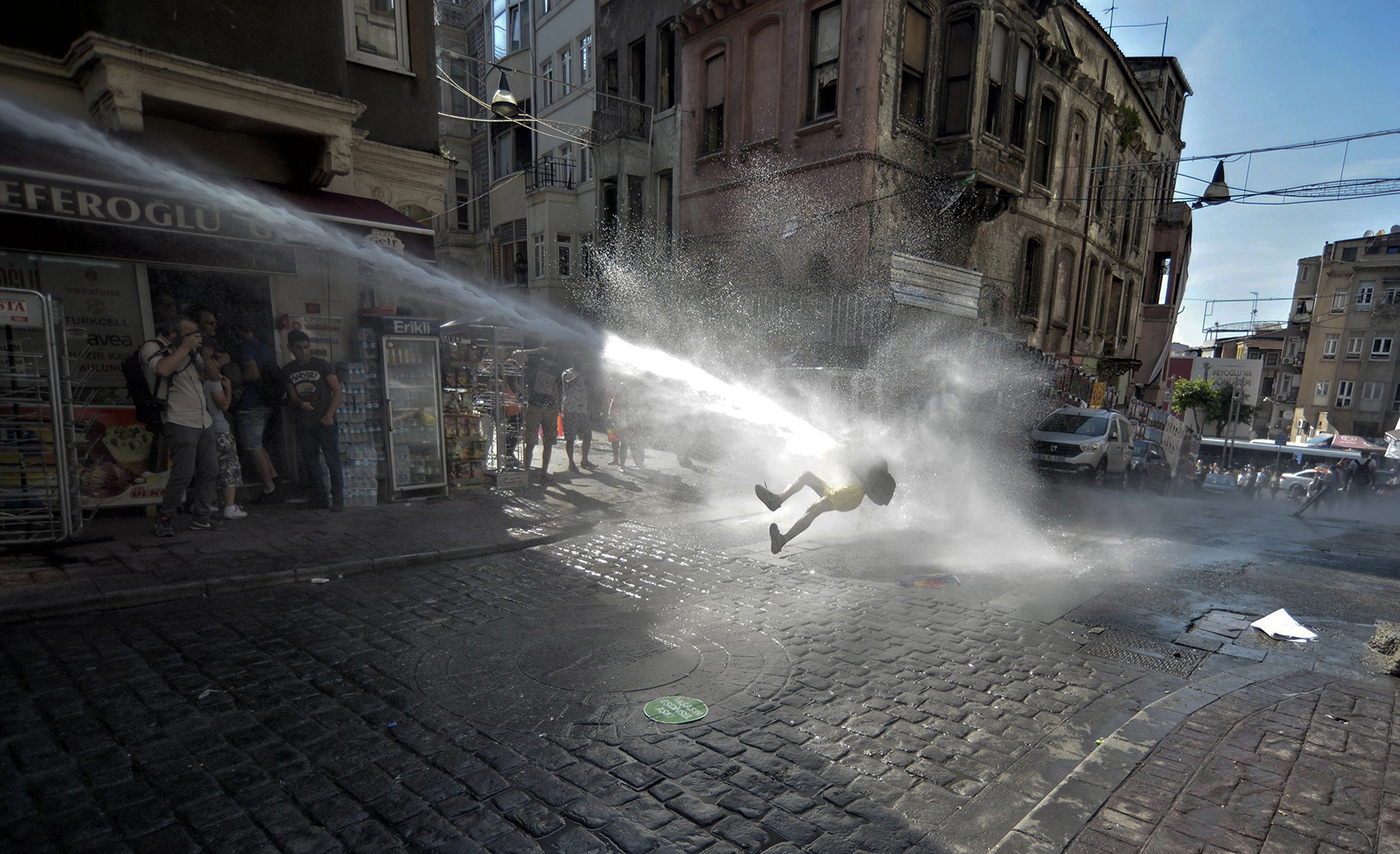 A demonstrator targeted by Turkish police water cannon during a rally on the occasion of the 13th annual Gay Pride Parade in Istanbul, Turkey, 28 June 2015.