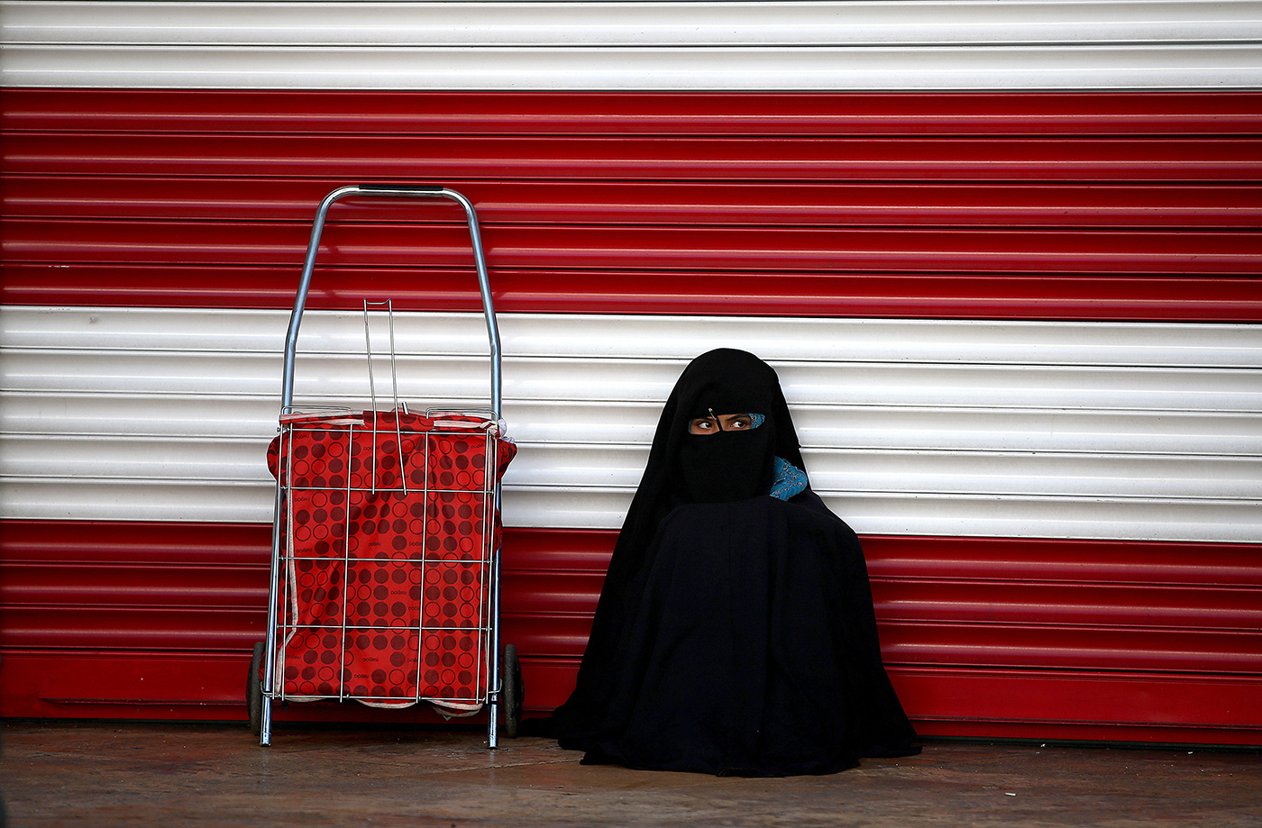 A girl in chador sits next to a closed shop in Sanliurfa, Turkey, 20 June 2018. Turkish President Recep Tayyip Erdogan announced on 18 April 2018 that Turkey will hold snap elections on 24 June 2018. The presidential and parliamentary elections were scheduled to be held in November 2019, but government has decided to change the date following the recommendation of the Nationalist Movement Party (MHP) leader Devlet Bahceli.