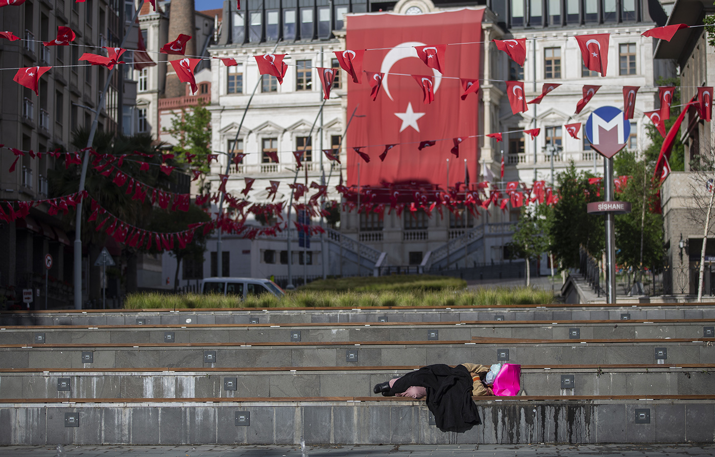  A homeless woman sleeps in front of the huge Turkish flag during a curfew amid the ongoing pandemic of the COVID-19 disease caused by the SARS-CoV-2 coronavirus in Istanbul, Turkey, 23 May 2020. 