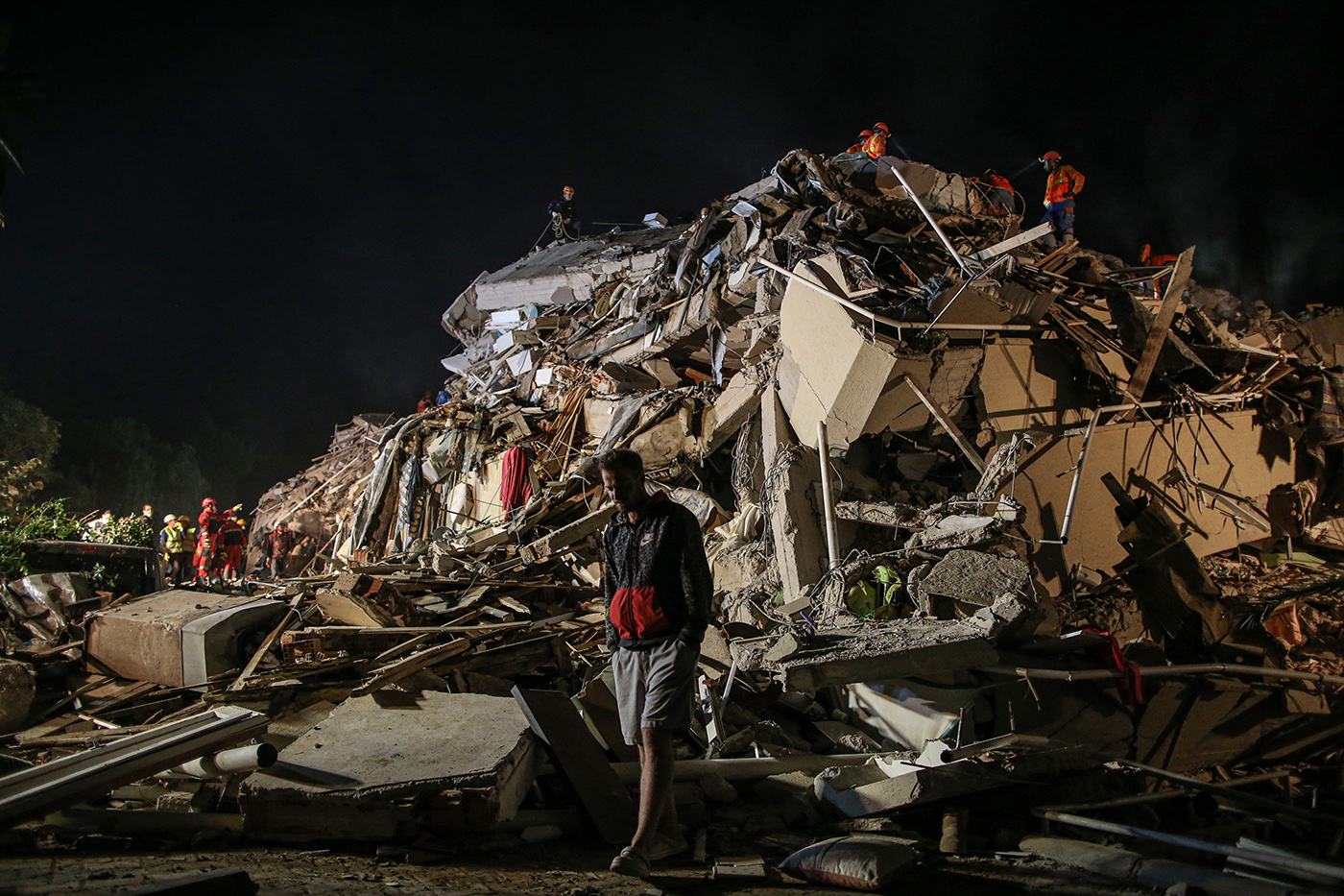 Rescue workers and people search for survivors at a collapsed building after a 7.0 magnitude earthquake in the Aegean Sea, at Bayrakli district in Izmir, Turkey, 31 October 2020. According to Turkish media reports, at least twenty people died while more than eight  hundreds were injured and dozens of buildings were destroyed in the earthquake.