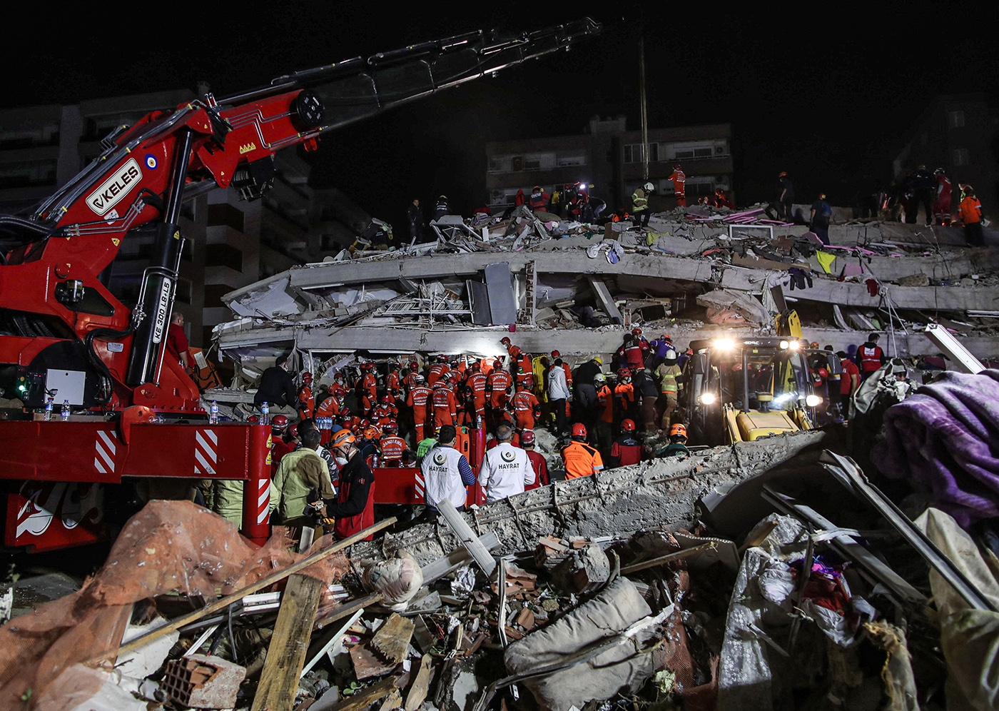 Rescue workers and people search for survivors at a collapsed building after a 7.0 magnitude earthquake in the Aegean Sea, at Bayrakli district in Izmir, Turkey, 30 October 2020. According to Turkish media reports, at least twelve people died while more than six hundreds were injured and dozens of buildings were destroyed in the earthquake.  EPA-EFE/ERDEM SAHIN