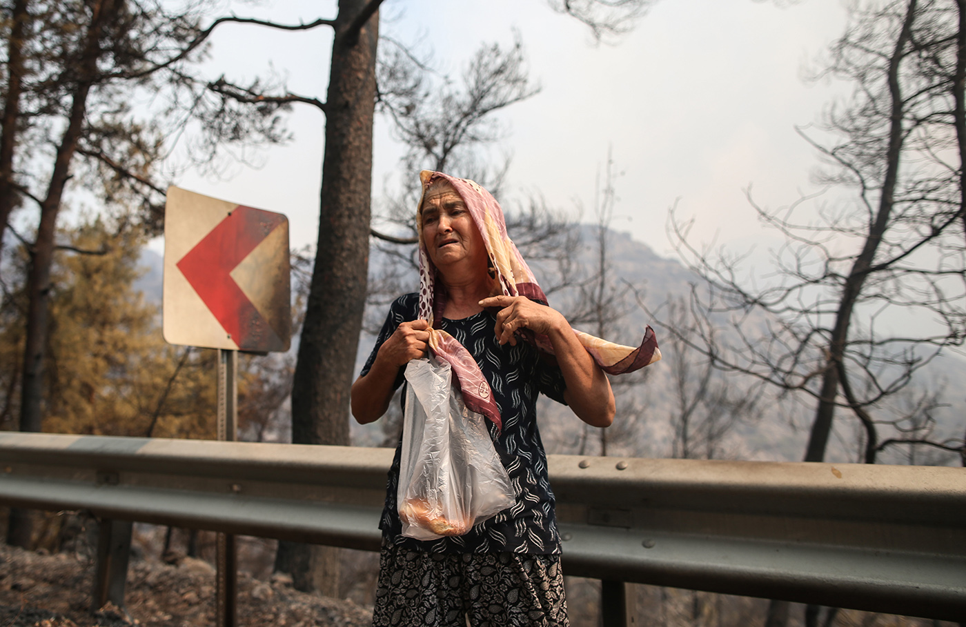 An old woman reacts as she evacuating her animals at the burned landed to a safe place due to wildfires at the Cokertme village of Milas district of Mugla, Turkey, 02 August 2021. Turkish Health minister Fahrettin Koca confirmed that eight people have lost their lives due to the wildfires raging in Turkey’s Mediterranean towns.