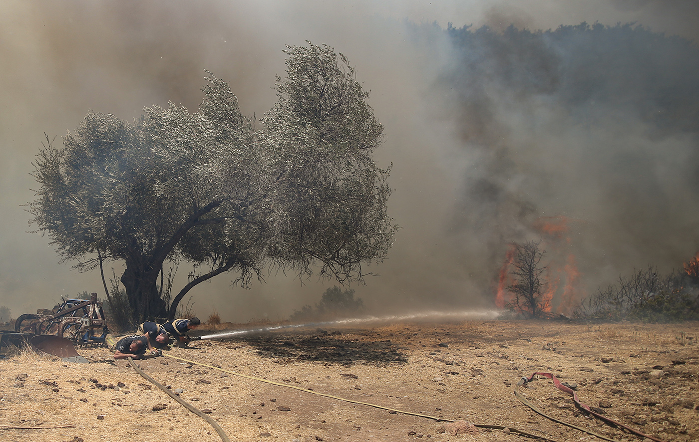 Members of Istanbul Fire Department fight with the wildfire burning at the Cokertme village of Milas district of Mugla, Turkey, 02 August 2021. Turkish Health minister Fahrettin Koca confirmed that eight people have lost their lives due to the wildfires raging in Turkey’s Mediterranean towns.