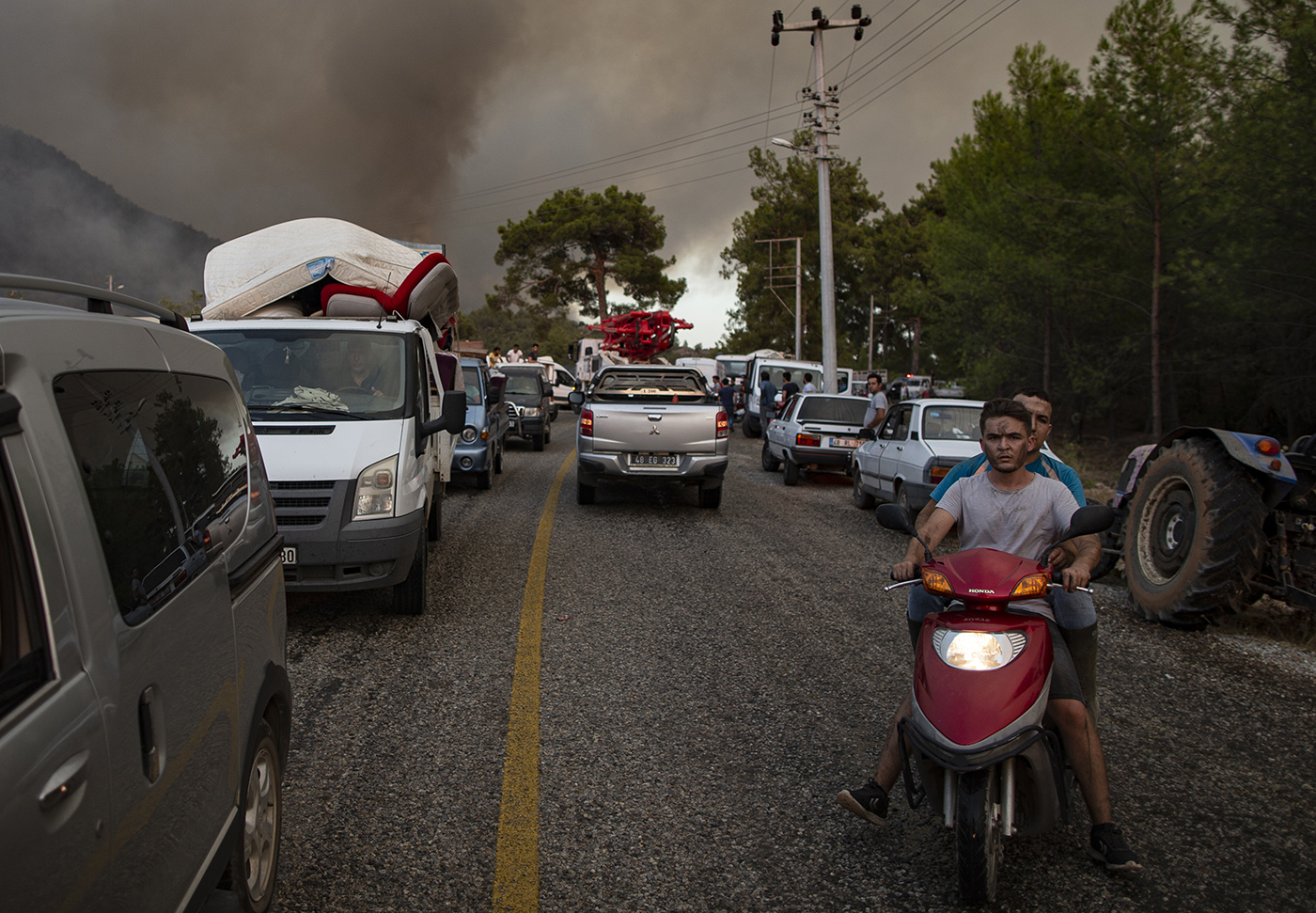 People leave from their home during the wildfires at the  Yuvarlakcay village of the Koycegiz district of Mugla, Turkey, 03 August 2021. Turkish Health minister Fahrettin Koca confirmed that eight people have lost their lives due to the wildfires raging in Turkey’s Mediterranean towns.