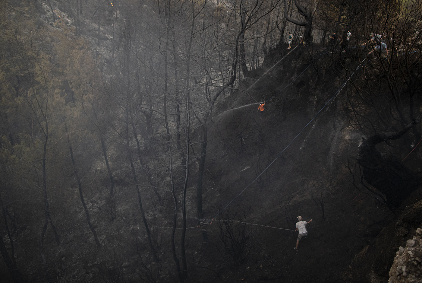 People try to put out the fire during the wildfires at the Yuvarlakcay village of the Koycegiz district of Mugla, Turkey, 03 August 2021. Turkish Health minister Fahrettin Koca confirmed that eight people have lost their lives due to the wildfires raging in Turkey’s Mediterranean towns.