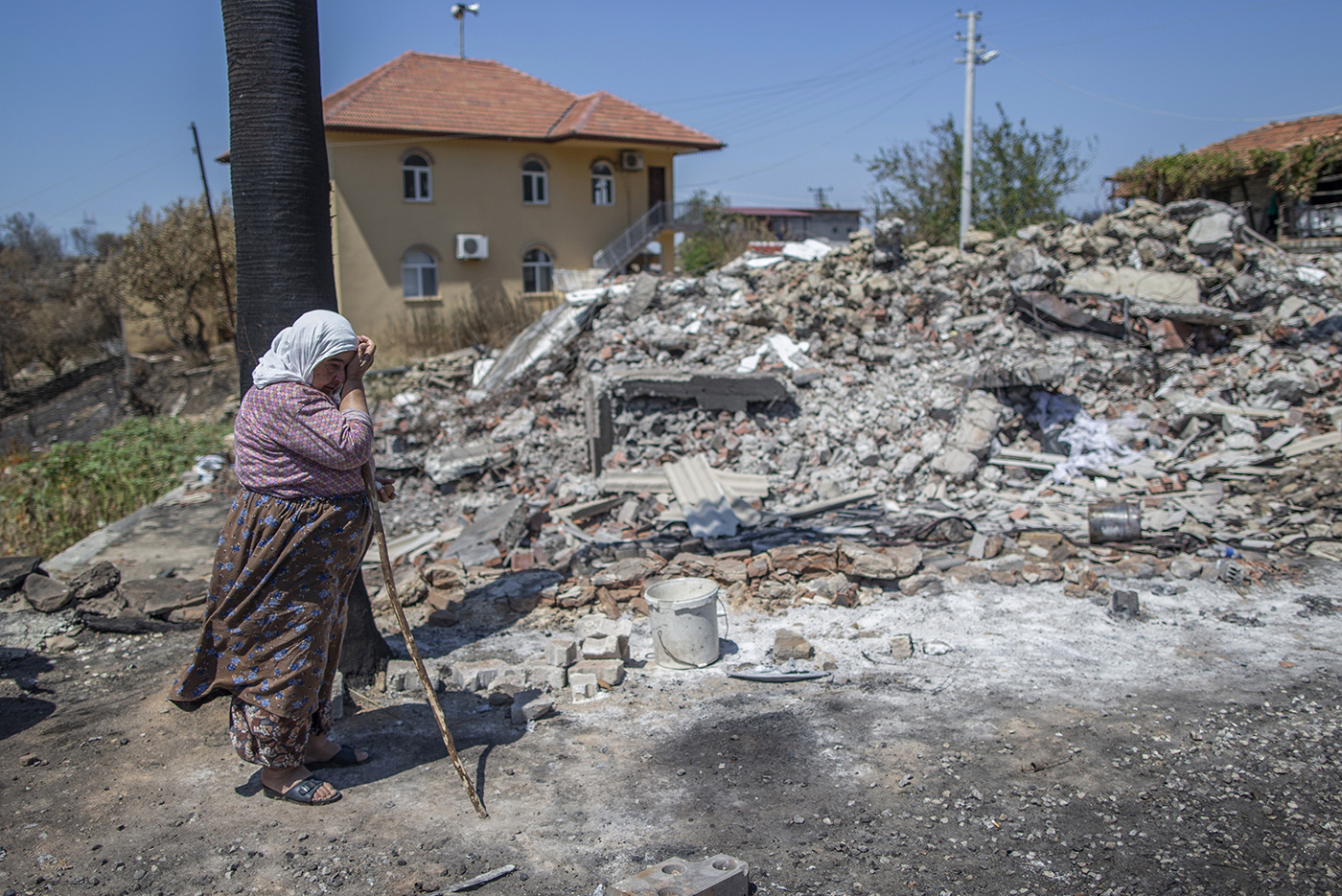 Cemile Gullu, cries in front of the wreckage burned of her house after a wildfire at the Bucak village of the Manavgat district of Antalya, Turkey, 10 August 2021.
