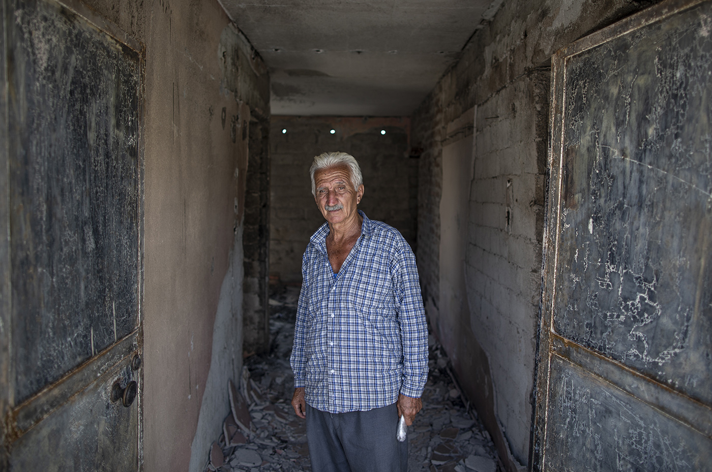 A man waits in his burnt house after a wildfire at the Evrenseki village of the Manavgat district of Antalya, Turkey, 10 August 2021.