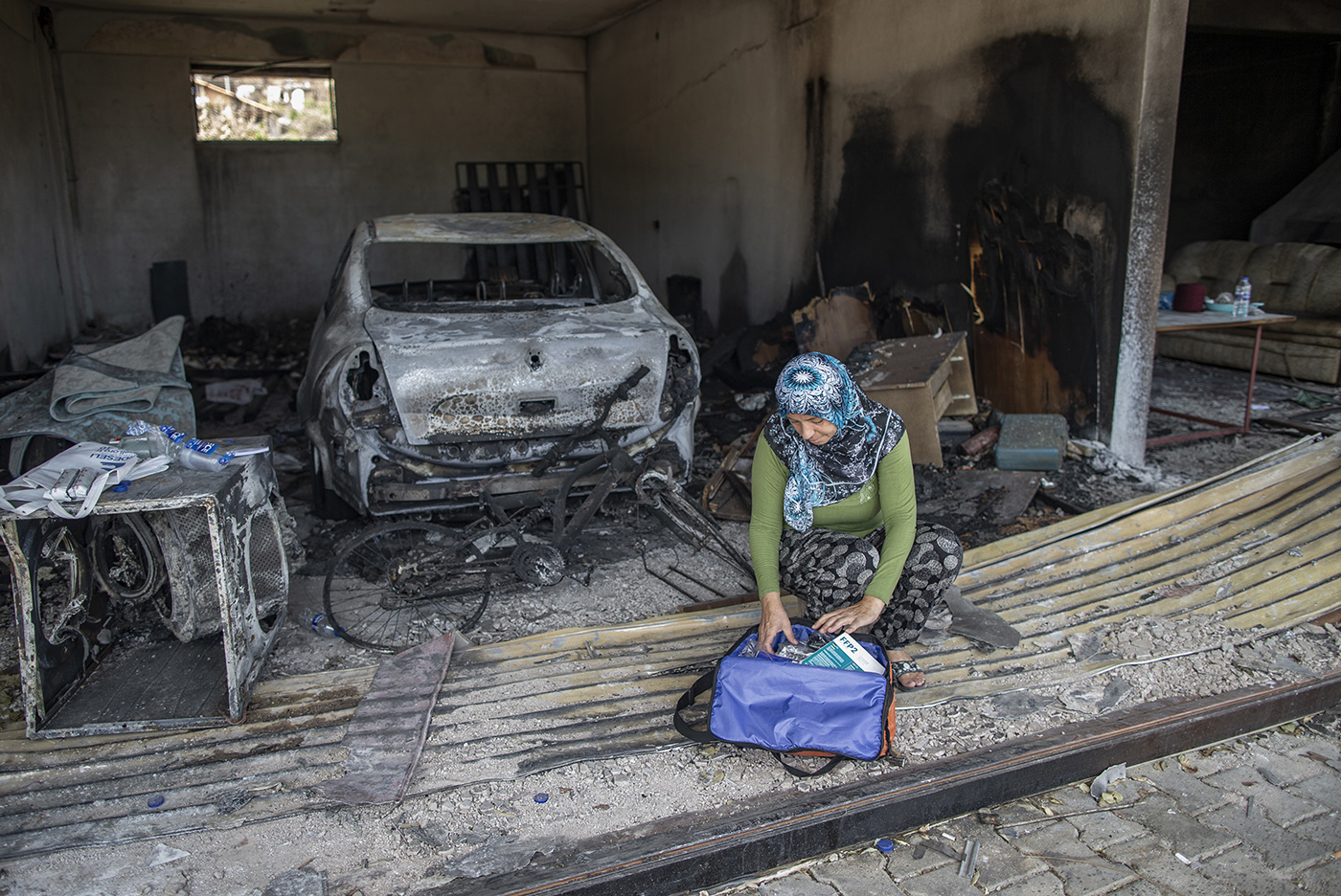 Azize Sert, looks a aid kit in her burnt house after a wildfire at the Evrenseki village of the Manavgat district of Antalya, Turkey, 10 August 2021.