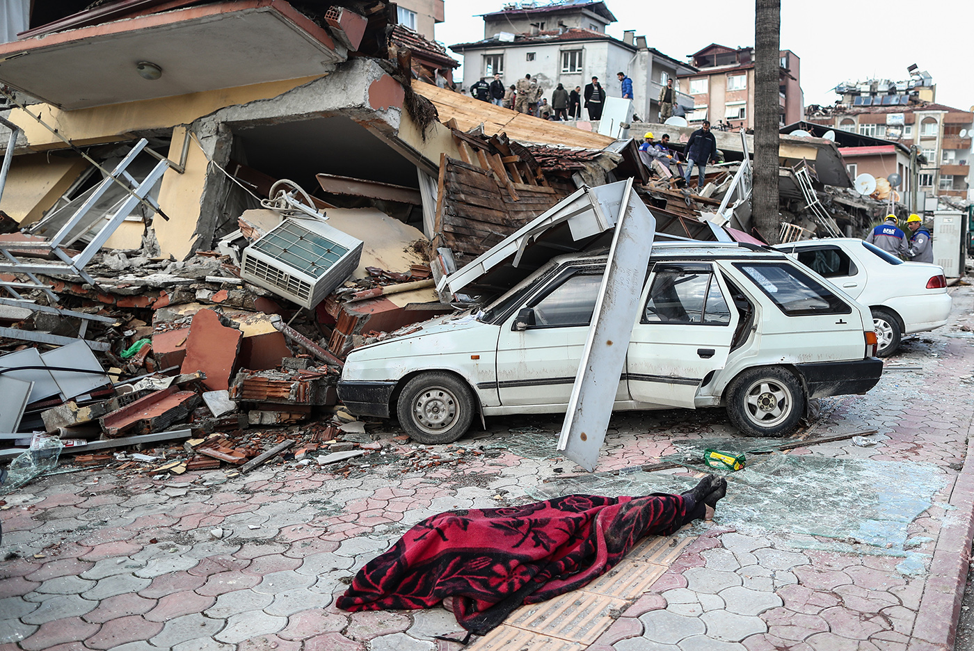 A body on the ground in front of a site of a collapsed building after an earthquake in Hatay, Turkey, 07 February 2023. According to the US Geological Service, an earthquake with a preliminary magnitude of 7.8 struck southern Turkey close to the Syrian border. The earthquake caused buildings to collapse and sent shockwaves over northwest Syria, Cyprus, and Lebanon. Thousands of people have died and more than seven thousand have been injured in Turkey, according to AFAD, Turkish Disaster and Emergency Management Presidency.